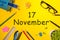 November 17th. Day 17 of last autumn month, calendar on yellow background with office supplies. Business theme