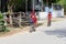 November 2018, School children boy girls uniform cycling village street, Vietnam