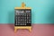 November 2023 monthly calendar on easel stand on pink and blue background