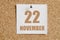 november 22. 22th day of the month, calendar date.White calendar sheet attached to brown cork board.Autumn month, day of
