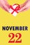 November 22nd. Festive Vertical Calendar With Hands Holding White Gift Box With Red Ribbon And Calendar Date