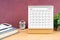 The November Monthly desk calendar for 2023 year and calculator on wooden table with red background