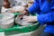 A novice student in the first lesson in pottery tries to make a product from clay on a potter`s wheel. reportage. clay centering.