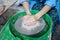 A novice student in the first lesson in pottery tries to make a product from clay on a potter`s wheel. reportage. clay centering.