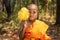 Novices smile are holding the leaves of the tree. Young Buddhist novices in forest in old temple at sunset time. Thailand.