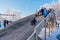 Novokuznetsk, Russia- January 07, 2019: Russian winter entertainment: children having fun tobogganing from wooden toboggan