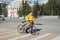 Novosibirsk, Russia-02.05.2020: a fast food delivery courier dressed in a yellow uniform delivers dinner on a bicycle