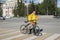 Novosibirsk, Russia-02.05.2020: a fast food delivery courier dressed in a yellow uniform delivers dinner on a bicycle