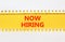 Now hiring symbol. Concept words Now hiring on beautiful yellow paper. Beautiful white paper background. Business marketing,