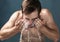 Now thats refreshing. a young man washing his face against a grey background.