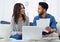 Now what paid secrets of yours will I find here. a happy young couple sitting on the sofa while going through paperwork