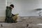 Nuclear disaster survivor in a post apocalyptic world, he is wearing a bandana mask and reading a book while sitting on