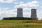 Nuclear factory in a grassy field with a cloudy sky in the background at daytime