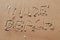 Nude beach letters written on the sand at the beach on a sunny day. Naked sunbathing. Naturalist lifestyle