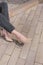 Nude casual beige shoes with a massive thick heel on the girl`s legs. Shoes on the pavement