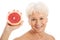 Nude old woman holding a grapefruit.