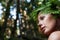 Nude woman with fern wreath in the forest river