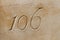 Number 106 carved in a limestone ashlar wall