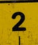 The number 2 is black on a yellow background. Grunge style, scratches and scuffs