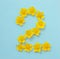 Number 2 on a blue background from yellow bright spring flowers. Children`s age, baby month, symbol of flowers