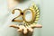 Number 20 and spikes of wheat over a person\'s fingers