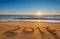 Number 2017 written on seashore sand at sunrise.