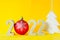 Number 2022 with concrete numbers and a Christmas tree ball on a yellow background with a Christmas tree figurine