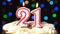 Number 21 on top of cake - twenty-one, birthday candle burning - blow out at the end. Color blurred background
