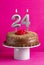 Number 24 candle - Chocolate cake on pink background