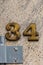 Number 34 tarnished brass house number on granite wall