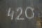 number 420 handwritten on shabby dark gray painted slat sheet steel garage door