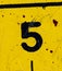 The number 5 is black on a yellow background. Grunge style, scratches and scuffs