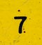 The number 7 is black on a yellow background. Grunge style, scratches and scuffs