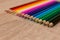 A number of colored pencils in a row on wooden background. Colorful photography. Selected focus on blue