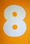 The number Eight painted in white against an Orange background