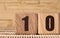 The number fifteen on a wooden cube on a beige background. Cube on a bamboo Mat..