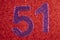 Number fifty-one purple over a red background. Anniversary.