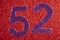 Number fifty-two purple over a red background. Anniversary.