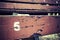 Number five painted on an old wooden seat.