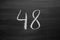 Number forty eight enumeration written with a chalk on the blackboard