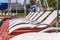 A number of many light loungers near the pool with a slide