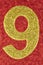 Number nine gold color over a red background. Anniversary.