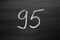 Number ninety five enumeration written with a chalk on the blackboard