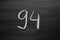 Number ninety four enumeration written with a chalk on the blackboard