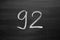 Number ninety two enumeration written with a chalk on the blackboard