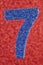 Number seven blue color over a red background. Anniversary