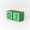 Number seven written on a wooden green cube