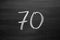 Number seventy enumeration written with a chalk on the blackboard