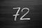 Number seventy two enumeration written with a chalk on the blackboard