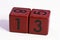 Number thirteen written on a red wooden cube of a calendar date